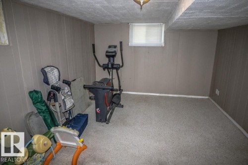 Room featuring paneled walls, a carpeted floor, and a window with blinds - 4814 51 Ave, St. Paul Town, AB - Indoor Photo Showing Gym Room