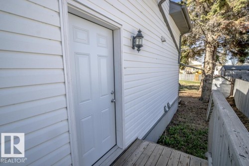 White six-panel door with brushed nickel hardware, flanked by white horizontal siding - 4814 51 Ave, St. Paul Town, AB - Outdoor With Exterior