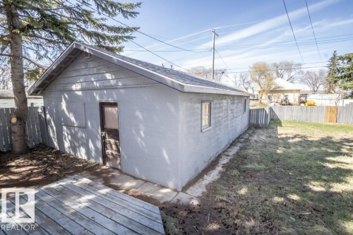 Detached garage with a pitched roof, exterior door, and two windows - 4814 51 Ave, St. Paul Town, AB - Outdoor