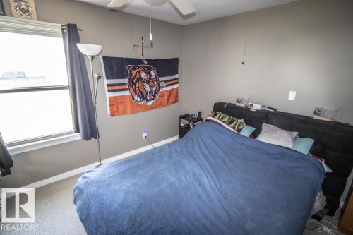 Room featuring wall-to-wall carpeting, neutral wall paint, and a window with white trim - 4814 51 Ave, St. Paul Town, AB - Indoor Photo Showing Bedroom