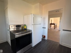 Kitchen area featuring a stainless steel range, and a white refrigerator - 