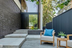 Modern exterior featuring dark brickwork and a sleek black entry door with a sidelight - 