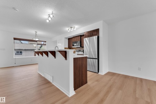 Open-concept kitchen and living area featuring light wood-finish flooring - 2143 32 Street, Edmonton, AB - Indoor Photo Showing Kitchen