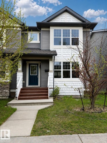 Two-story residence featuring a dark gray and white exterior with diverse siding textures including horizontal panels, shake, and stone accents - 2143 32 Street, Edmonton, AB - Outdoor With Facade