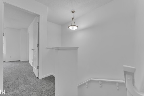 Upper-level hallway featuring a pendant light fixture, white walls, and gray carpeting - 2143 32 Street, Edmonton, AB - Indoor Photo Showing Other Room