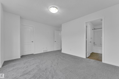 Neutral paint colors complement the grey carpeting throughout this space - 2143 32 Street, Edmonton, AB - Indoor Photo Showing Other Room