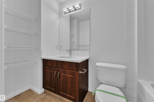 Bathroom featuring a dark wood-finish vanity with a white countertop and integrated sink - 2143 32 Street, Edmonton, AB - Indoor Photo Showing Bathroom