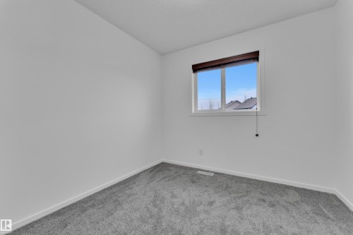 Room featuring light grey carpet, white baseboards, and a window with a dark wood-finish blind - 2143 32 Street, Edmonton, AB - Indoor Photo Showing Other Room