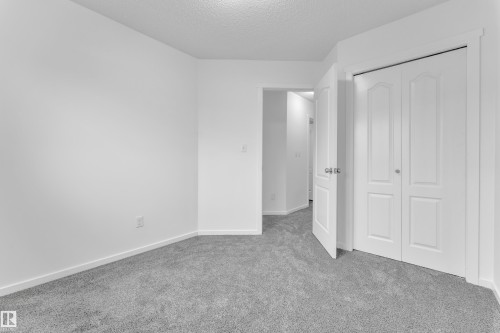 Neutral wall finishes with a textured ceiling, grey carpet flooring, and white trim - 2143 32 Street, Edmonton, AB - Indoor Photo Showing Other Room