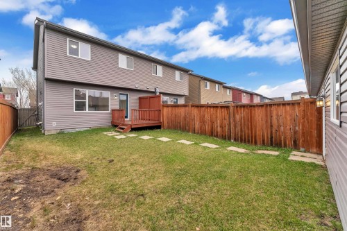 Expansive rear yard featuring a wooden privacy fence and a dedicated wooden deck with steps - 2143 32 Street, Edmonton, AB - Outdoor With Exterior