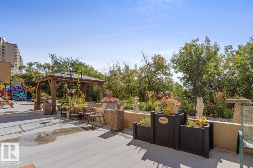 Patio space featuring Gazebo, BBQ Area, Tables, Community Garden & a Colourful Mural - 602 12303 Jasper Avenue, Edmonton, AB - Outdoor With Deck Patio Veranda