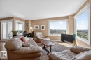 Spacious living area featuring expansive windows with scenic green space and river. West & South Facing Views; - 602 12303 Jasper Avenue, Edmonton, AB  - Indoor Photo Showing Living Room 