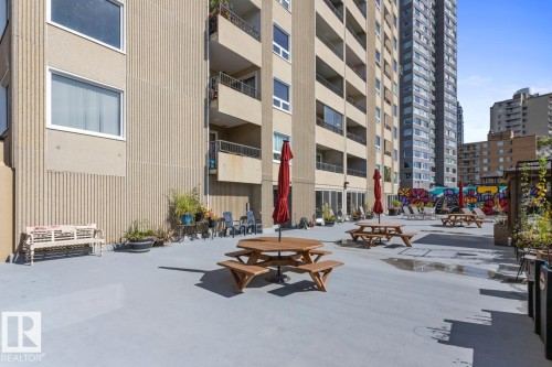 Patio space featuring BBQ Area, Tables, Community Garden & a Colourful Mural - 602 12303 Jasper Avenue, Edmonton, AB - Outdoor With Balcony