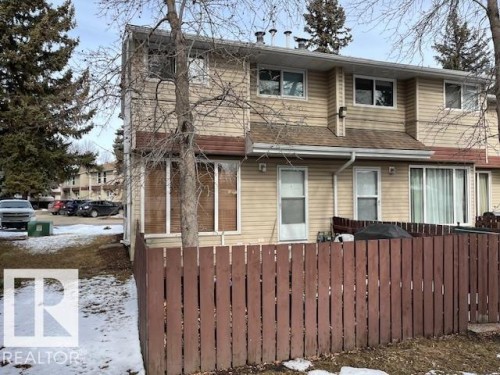 The property features a private fenced patio area, tan siding, and white-framed windows - 350 Clareview Road, Edmonton, AB - Outdoor