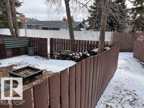 The property features a fenced yard with a fire pit, a wood fence, and mature trees - 350 Clareview Road, Edmonton, AB - Outdoor