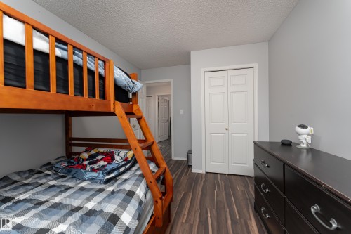 Room featuring wood-finish flooring, light grey painted walls, and a textured ceiling - 2 13403 Cumberland Road, Edmonton, AB - Indoor Photo Showing Bedroom
