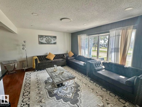 Living area featuring wood-finish flooring, recessed lighting, and a prominent bay window - 8620 137 Avenue, Edmonton, AB - Indoor Photo Showing Living Room