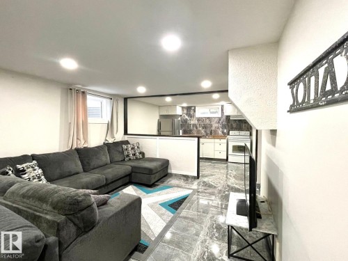 Open concept living area featuring recessed lighting, a window with horizontal blinds, and durable stone-finish flooring - 8620 137 Avenue, Edmonton, AB - Indoor Photo Showing Living Room