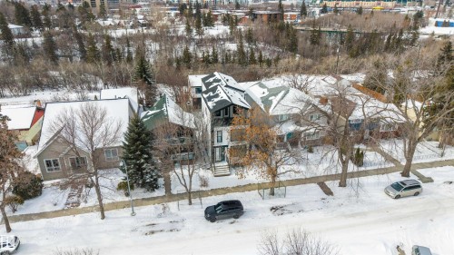The property features a distinctive dark-colored exterior with white trim and a prominent peaked roofline - 7927 112S Avenue, Edmonton, AB - Outdoor