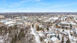 Aerial view showcasing the surrounding neighborhood with various buildings and snow-covered terrain - 