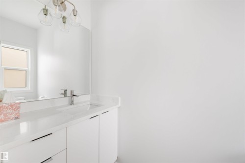 Bathroom featuring a white vanity with drawers and cabinets, a white countertop, and a chrome faucet - 7927 112S Avenue, Edmonton, AB - Indoor Photo Showing Bathroom