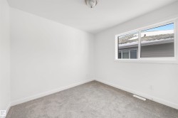 This room features white walls, light grey carpet, and a window providing natural light - 