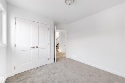 This space features light grey carpeting, white walls, and a window providing natural light - 