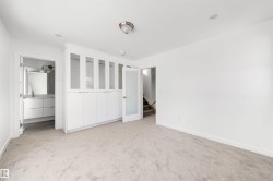 This living space features soft carpet flooring, a ceiling-mounted light fixture, and recessed lighting - 