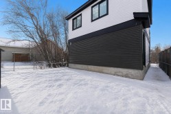 Exterior side elevation featuring white and dark gray horizontal siding, black trim, and black-framed windows - 