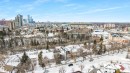 Aerial view showcasing the neighborhood with residential properties, city buildings, and a stadium in the distance - 7927 112S Avenue, Edmonton, AB  - Outdoor With View 