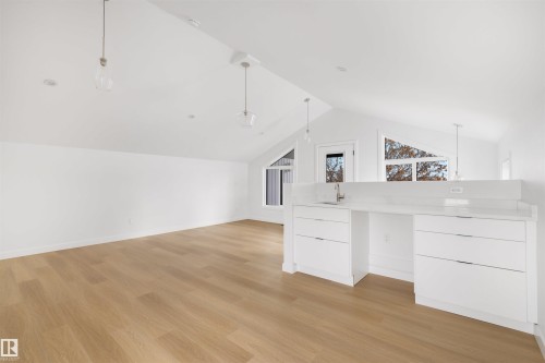 Spacious room with light wood flooring and crisp white walls - 7927 112S Avenue, Edmonton, AB - Indoor Photo Showing Other Room