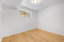 Room featuring light wood flooring, white walls, and a window providing natural light - 