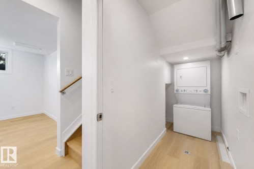 Dedicated laundry area featuring a stacked washer and dryer unit - 7927 112S Avenue, Edmonton, AB 