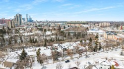 Aerial view showcasing the neighborhood with residential properties, city buildings, and a stadium in the distance - 