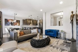 Expansive living area featuring dark wood-finish flooring, recessed lighting, and a decorative wall niche - 