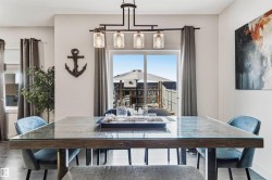Dining area featuring a contemporary linear chandelier with clear glass shades. - 