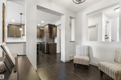Open-concept interior featuring dark wood-finish flooring throughout - 