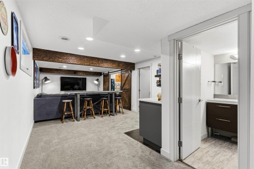 Lower level featuring an exposed wood-finish beam, recessed lighting, and a sliding barn door - 7343 Armour Crescent, Edmonton, AB - Indoor Photo Showing Other Room