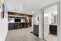 Lower level featuring an exposed wood-finish beam, recessed lighting, and a sliding barn door - 
