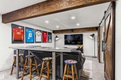 Recreation room featuring exposed wood beams, recessed lighting, and a barn door entry to bedroom. - 