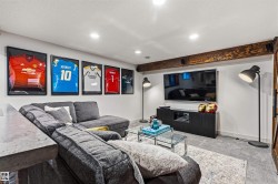 Recreational space featuring recessed lighting, a wood beam and media area. - 