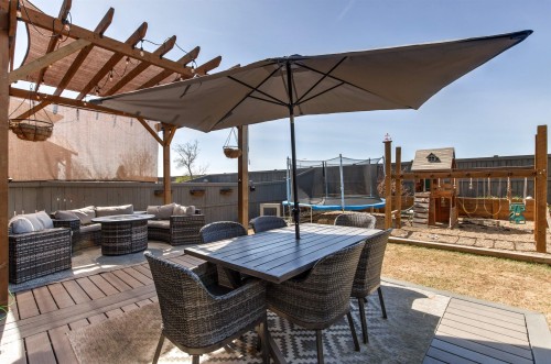 Expansive outdoor living area featuring a wood pergola with shade covering, a spacious deck, and a dining area  with gas hook-up for bbq. - 7343 Armour Crescent, Edmonton, AB - Outdoor With Deck Patio Veranda With Exterior