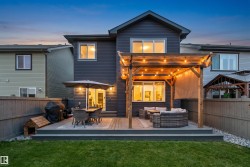 Spacious backyard featuring a multi-level composite deck, wooden pergola with string lighting. - 