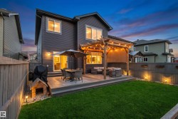Backyard featuring a multi-level deck with a pergola, string lighting, and a privacy screen - 