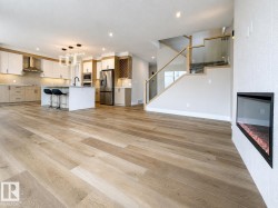 Spacious open-concept interior featuring light wood-finish flooring - 