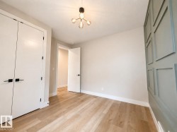 Light wood-finish flooring complemented by a decorative accent wall with paneling - 