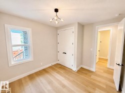 Neutral tone walls with white trim, wood-finish flooring, and a contemporary ceiling light fixture - 