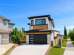 Contemporary exterior featuring a black garage door with frosted glass panels, stone veneer accents, wood-finish siding, and a concrete driveway - 