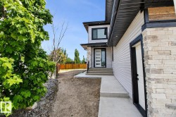 Modern exterior featuring light-colored siding and stacked stone accents - 