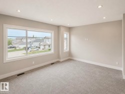 Spacious room featuring gray carpet flooring, neutral paint palette, and recessed ceiling lighting - 